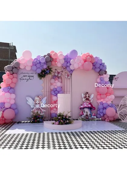 The full outdoor setup for the fairy and butterfly themed party, featuring a checkered floor and multiple backdrops.