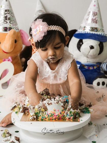 Hands deep in the cake! This is what a successful cake smash looks like.