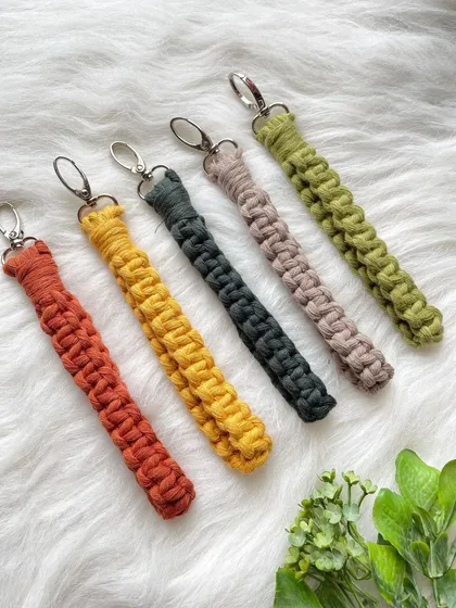 My practical and stylish macrame wristlet keychains, shown here in a palette of warm, earthy tones including rust, mustard yellow, charcoal, taupe, and olive green. The sturdy metal clasp keeps your keys secure while the soft strap fits comfortably around your wrist.