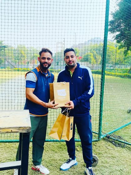 A coach presenting a prize to a player from the winning team.