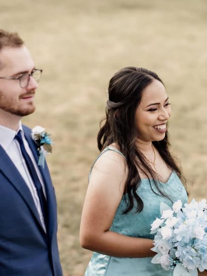 A bridesmaid enjoying the outdoor ceremony, holding a beautiful blue and white bouquet that I custom-made for the wedding party.