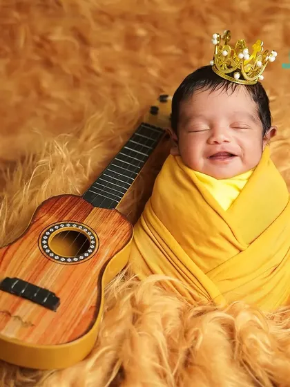 A little prince with a happy grin, ready to rock the world. We love capturing these spontaneous expressions of joy during our newborn sessions.