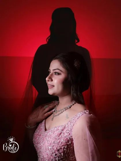 An artistic portrait of the bride against a red background, with her silhouette creating a dramatic effect.