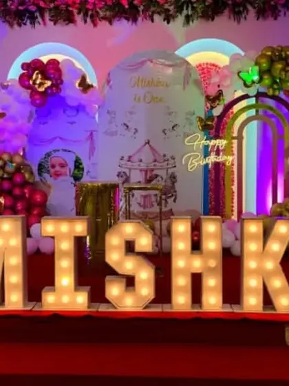 A spectacular carousel and butterfly themed birthday stage with large marquee letters spelling 'MISHKA'.