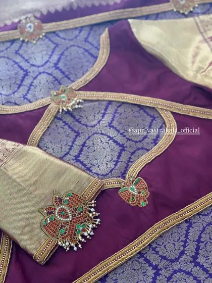 The back of the blouse features a stylish cutout, accentuated with embroidered borders and pendants.