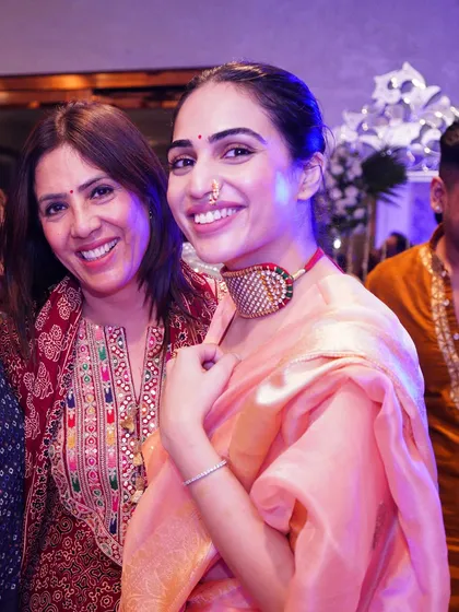 A happy moment with my mother. For this event, I wore a light peach organza saree with a unique choker, showing how modern jewelry can style a traditional outfit.