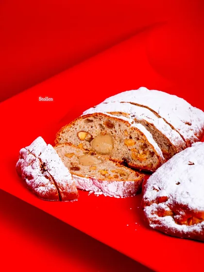 A sliced Stollen, showing the dense, fruity interior and the marzipan center.
