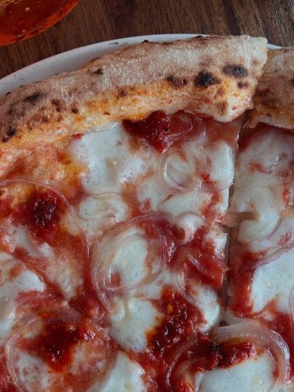 A slice of our Goan Sausage pizza, ready to be devoured.