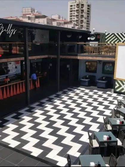 We design experiences, not just spaces. For Gilly's restaurant, we created a bold and energetic atmosphere with graphic chevron flooring and a multi-level layout perfect for a lively crowd. This is an example of our commercial design work for the hospitality industry.