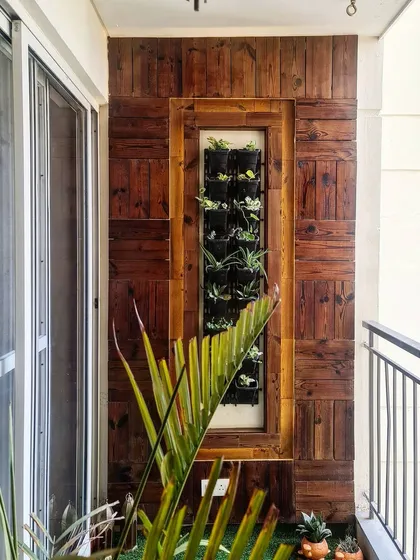 We designed this balcony with a custom vertical garden set within a reclaimed wood panel frame. This solution brings a significant amount of greenery to a small space, creating a beautiful natural view for the adjoining dining area.