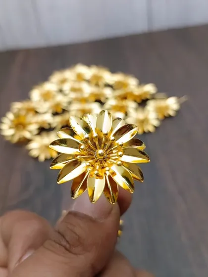 A pair of German silver flowers with a gold finish, perfect for offering to deities during pooja or as a small, auspicious gift.