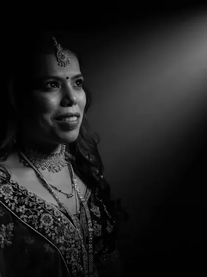 A single beam of light can tell a powerful story. For this black and white bridal portrait, we used a spotlight effect to draw the eye directly to the bride's hopeful gaze, creating a dramatic and emotive image that feels both classic and modern.