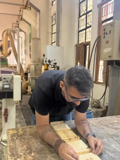 The student inspects the alignment of the glued-up panels for the box. Careful preparation and clamping are critical for achieving tight, gap-free joints.