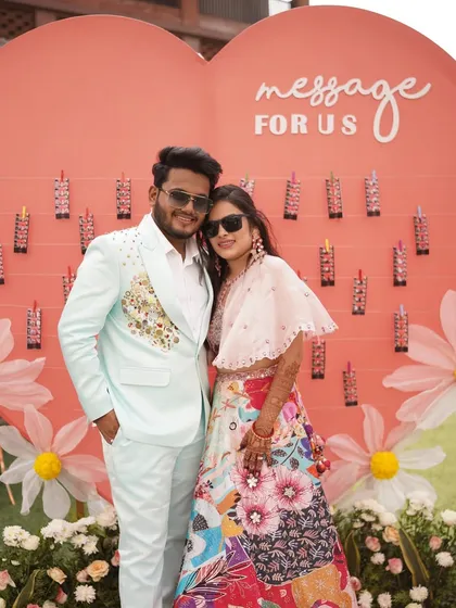 A couple poses in front of a custom 'Message For Us' wall at their carnival event. This interactive installation allowed guests to leave personal notes, adding a heartfelt touch to the fun-filled day.
