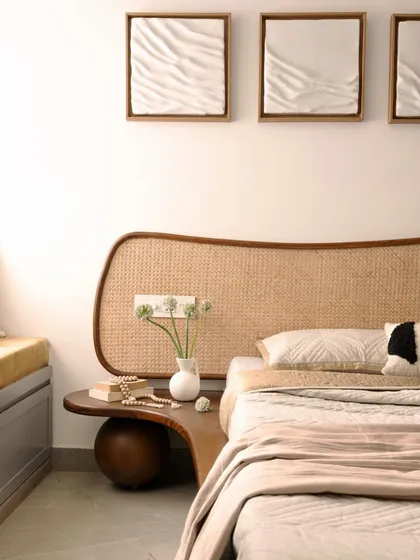For this bedroom in a compact city apartment, I designed a custom bed with an organically shaped, woven cane headboard that extends into a floating bedside table. This piece combines form and function, creating a soft, natural focal point while saving space.