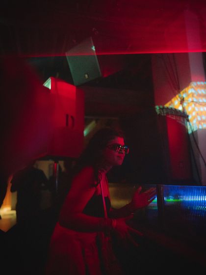 A clubber enjoying the music, framed by the lights and projections. It's all about creating a space where people can feel free.