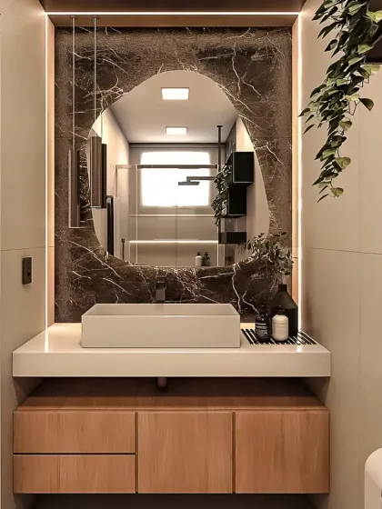 This bathroom vanity set shows how I bring modern luxury into compact spaces. The floating wooden cabinet provides storage without feeling heavy, complemented by a vessel sink and a custom-shaped, backlit mirror for a touch of drama.