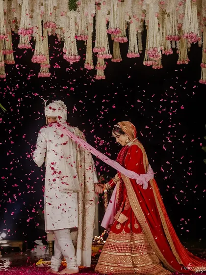 The couple taking their sacred vows around the fire, with petals showering down on them. A truly magical Phera moment.