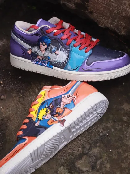 A battle of rivals on your feet. This pair of Air Jordan 1s features Naruto on one shoe and Sasuke on the other, captured in the middle of a fight. The artwork wraps around the shoe, making it a dynamic piece from every angle.