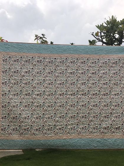 A large quilt featuring a single, beautiful floral fabric, elegantly framed with complementary borders.