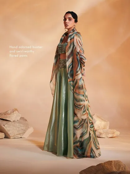 The Adoree Cape Set, where the hand-adorned bustier and flared pants are complemented by the dramatic, oversized printed cape.