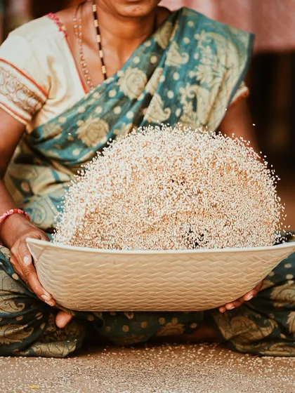 This powerful image captures a moment of tradition and authenticity. It shows one of the local women from the farm, showcasing the raw ingredients with pride. This is the kind of storytelling that builds a real brand connection.