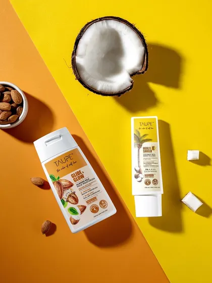 A dynamic flat lay for Taupe using a split-color background. This composition is modern and eye-catching, highlighting two key products and their ingredients in a graphically pleasing way.
