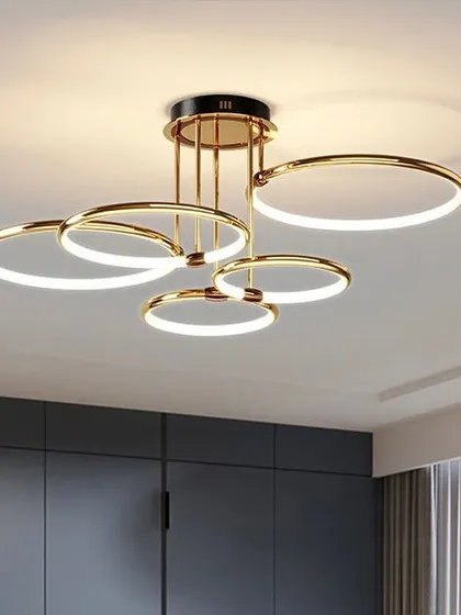 A contemporary ceiling light with five interlocking gold rings. This flush-mount fixture provides a modern alternative to a traditional chandelier.