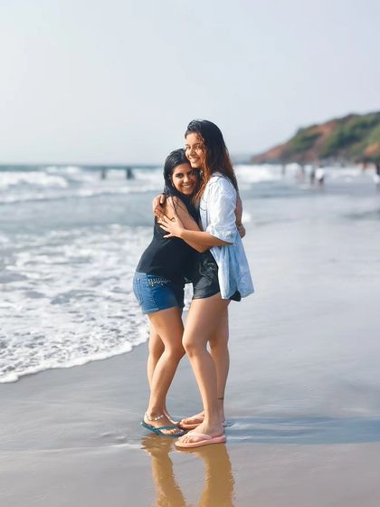 A warm, candid moment of two friends hugging on the beach. This photo is all about capturing the genuine connections and memories made while traveling.