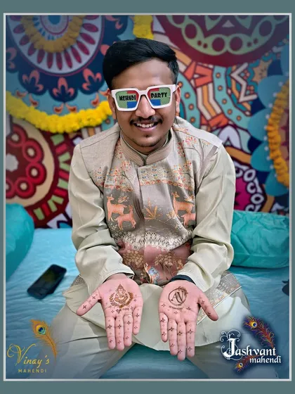 Having a great time at the mehndi party. This groom chose a minimal design with a Ganesh motif and his partner's initial.