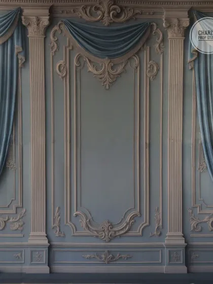 An elegant and stately backdrop of a classic European-style wall with ornate molding and beautiful blue drapery.