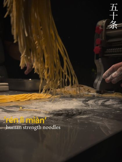 A dramatic shot of freshly made 'ren li mian' or "human strength noodles." The name reflects the intense manual labor required to achieve their perfect texture, a process we were thrilled to showcase at The Conservatory.
