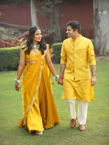 A sweet and simple portrait from a Haldi function. The couple holds hands and shares a look, dressed in beautiful shades of yellow, perfectly matching the theme of the day.