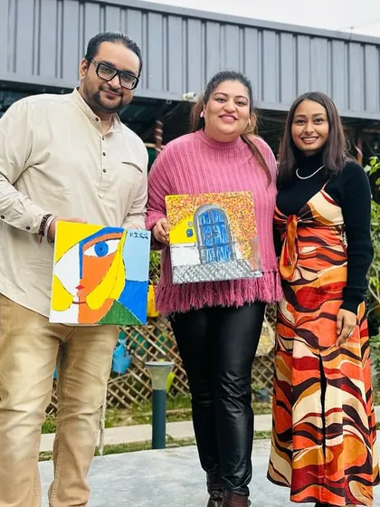 More proud artists from a Sip and Paint party! It's amazing to see the variety of styles, from a colorful abstract face to a charming doorway scene. Everyone brings their own personality to the canvas.