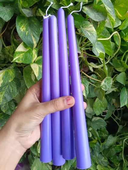 A set of four deep purple taper candles.