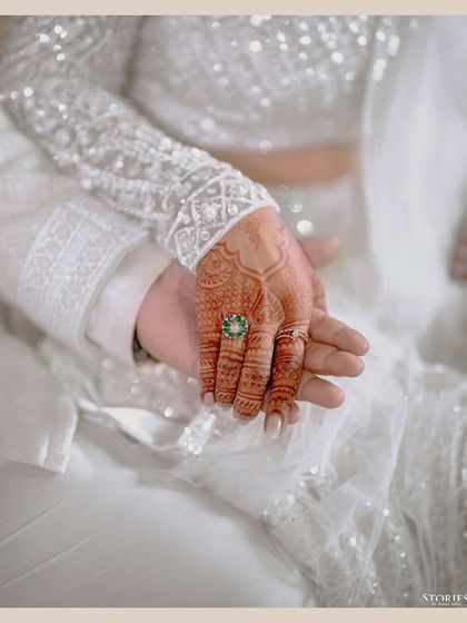 A close-up shot of the couple's hands after the ring ceremony, showcasing the beautiful ring and henna.