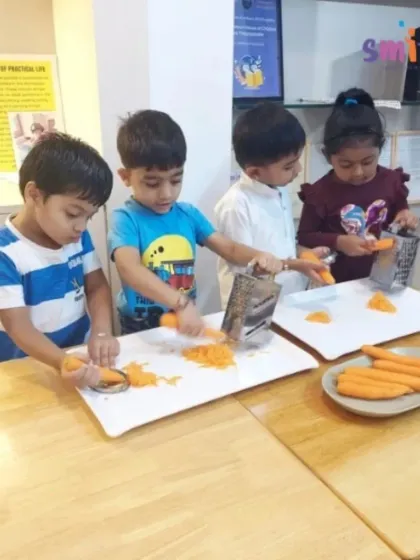 Our children work together to prepare a healthy snack, grating carrots for a tricolour salad. This practical life exercise teaches them valuable kitchen skills, promotes teamwork, and develops their fine motor coordination.