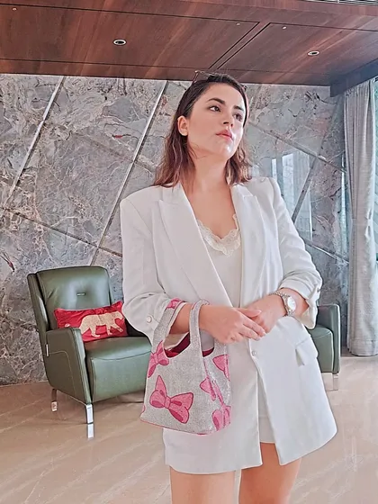 This chic white blazer and shorts set isn't just for the daytime. Paired with a lace camisole and a cute pink bow-detailed bag, it becomes a sophisticated and stylish option for an evening party or dinner.