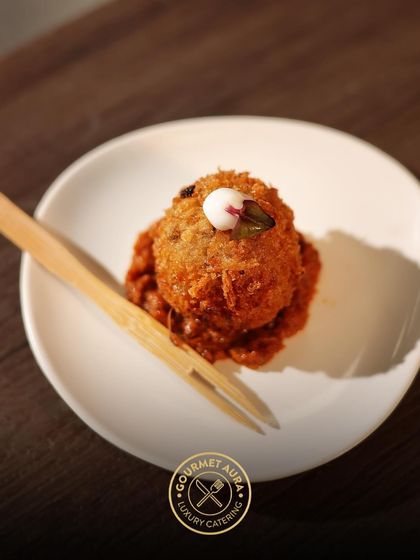A delicious fried appetizer served on a minimalist white plate with a bamboo fork. This single bite is packed with flavor and showcases our focus on quality ingredients.