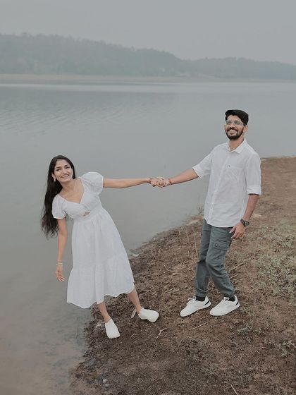 A duplicate of 297, showing a playful, leaning pose on the edge of the lake.