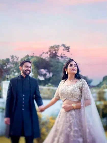 An engagement portrait taken during the magical twilight hour, with the colorful sky adding a dreamy quality to the photograph.