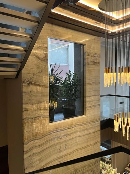 An Art Deco inspired space where a stunning centerpiece light fixture adds a touch of elegance. Its bold presence ties the double height space together, creating a luxurious and captivating ambiance.