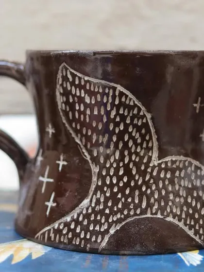 'The Lost Marines' is a set of three mugs I created using the Mishima technique on black clay. I carved the designs and inlaid them with white slip, creating a stark, beautiful contrast that I love.