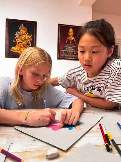 Collaboration and peer learning are a big part of our classes. Here, one student helps another with her drawing, sharing tips and encouragement.