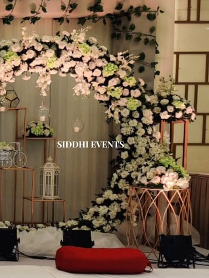 A detailed shot of the floral circle decor, showing the charming accents like a miniature bicycle and birdcage lantern nestled within the arrangement.