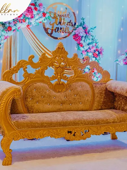 A close-up of the royal gold-finished sofa, a key element in many of my grand reception stage designs. It adds a touch of opulence and provides a perfect seat for the happy couple.