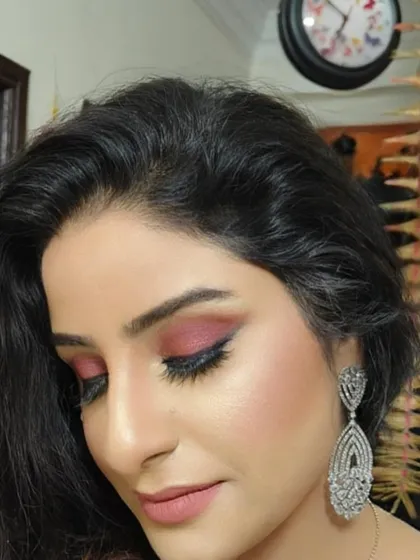 A side profile showing the beautiful shimmer on the eyelid and the expertly applied winged eyeliner, sharp enough to kill. The highlight on the cheekbone adds a perfect glow.