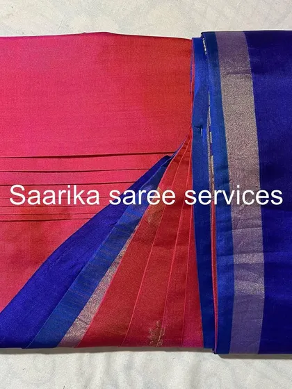 A pink and blue half-and-half saree, folded to show both colors.