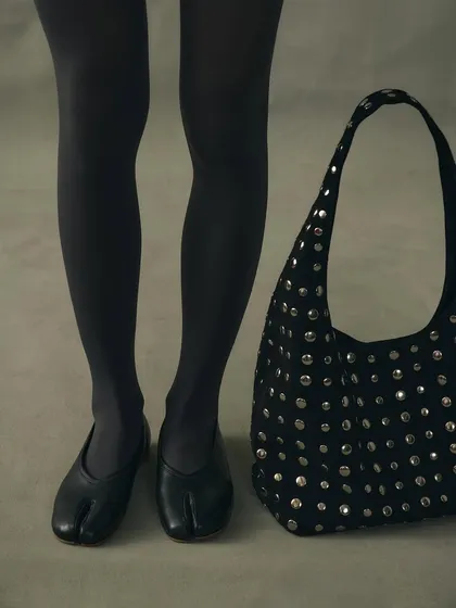 No rules, just rhythm. The black leather Tabi flat paired with our studded Icon bag. This look is about playing with silhouettes and textures to create a modern edge that is all your own.