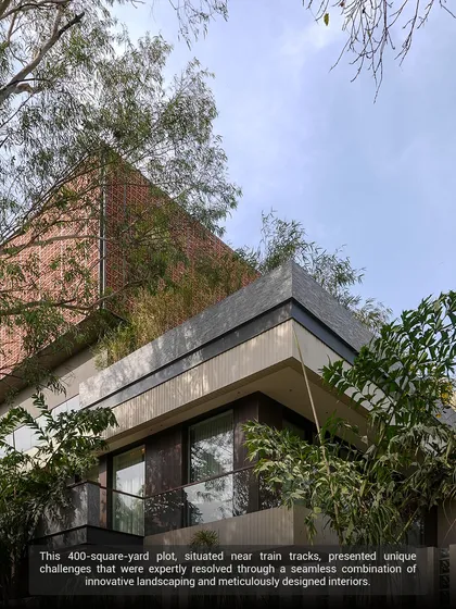 This 400-square-yard plot, once a timeworn bungalow, was revitalized into a luminous sanctuary. The design uses innovative landscaping with dense perimeter planting to buffer noise from nearby train tracks, creating a peaceful urban oasis.